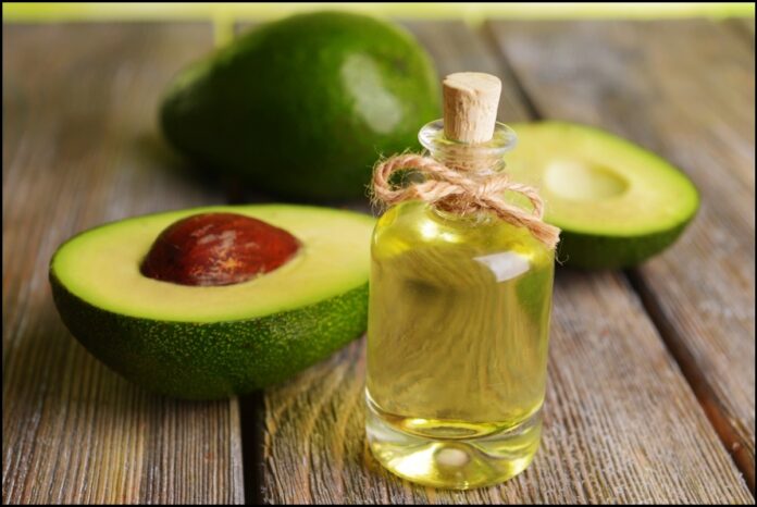 Halfed-Avocado-fruit-and-Avocado-Oil-on-Wooden-Table