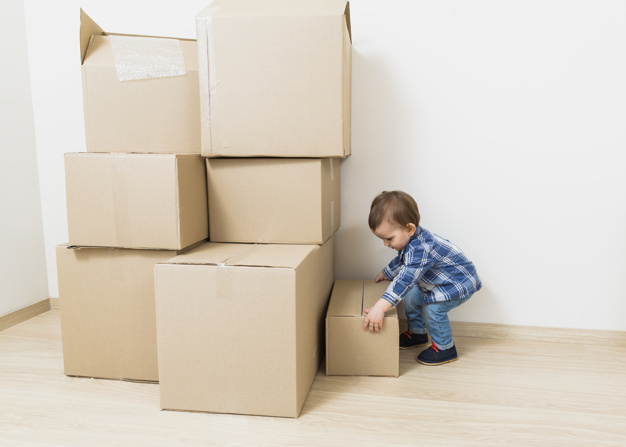 side-view-little-baby-boy-carrying-cardboard-boxes-from-floor