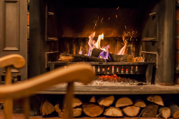 Home comfort. Rocking chair near the fireplace. Photo of interio
