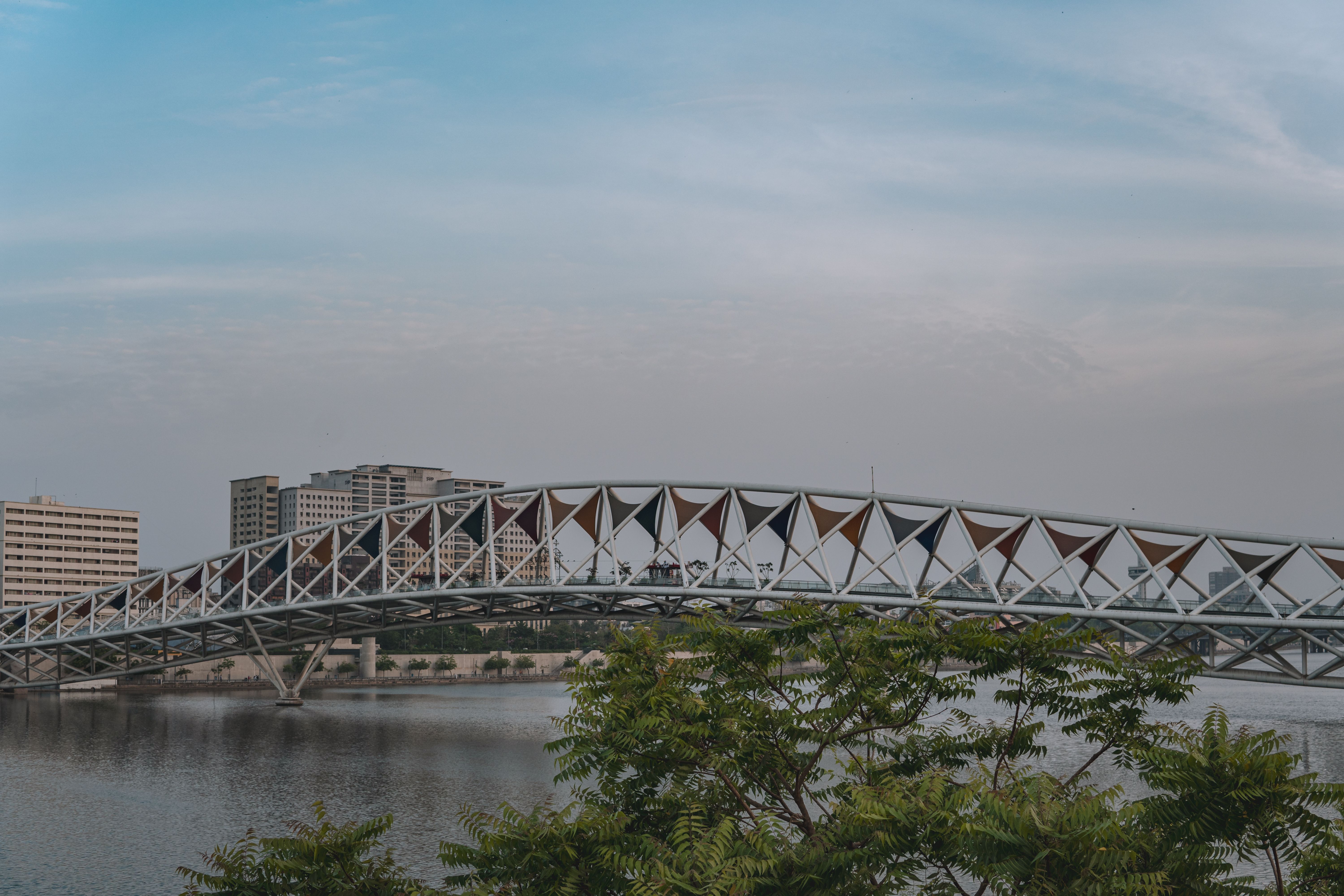 Stylish pedestrian bridge spanning the Sabarmati River with the Ahmedabad skyline behind