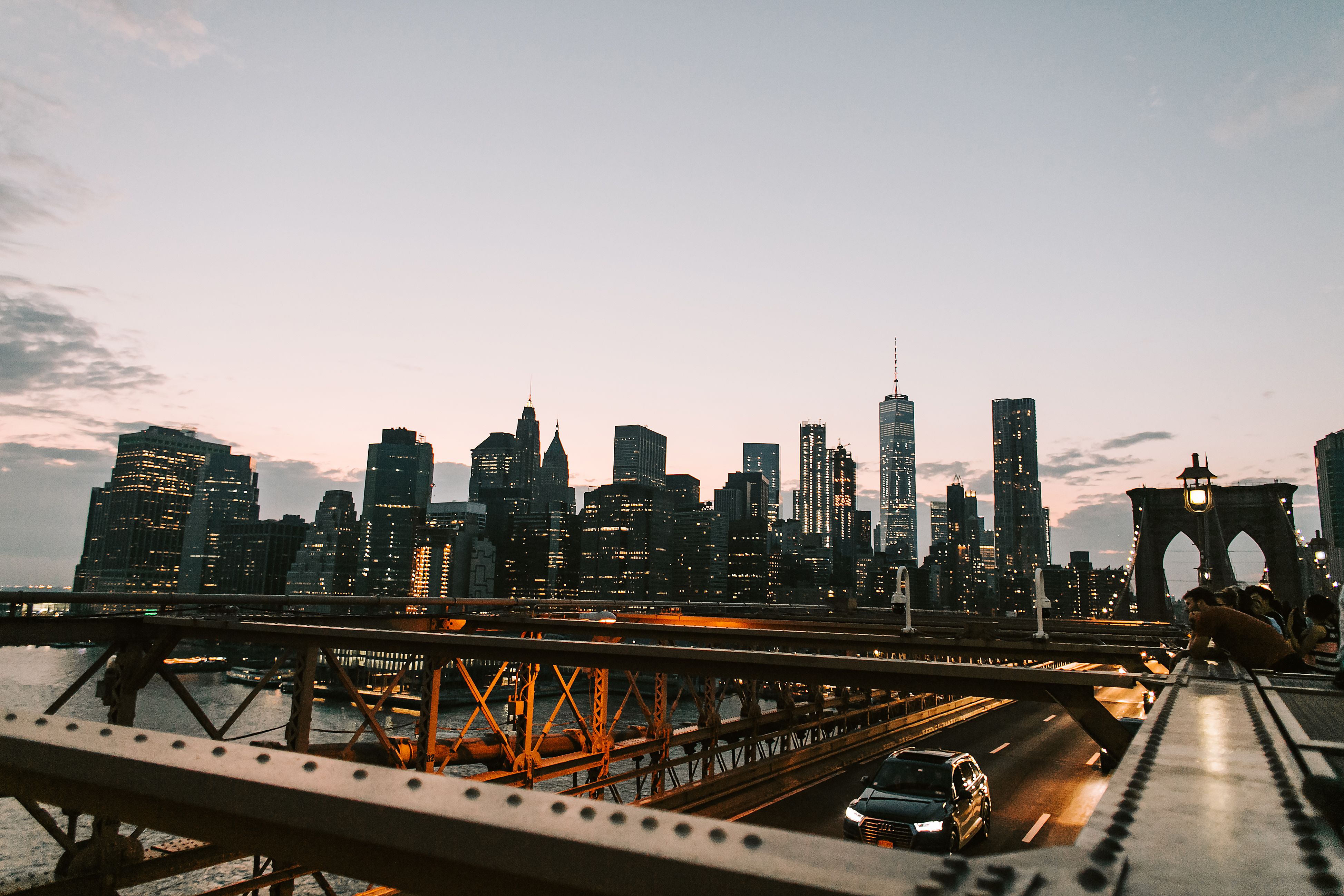 Illuminated New York City skyline at dusk seen from the Brooklyn Bridge, one of the best cities for nightlife and food