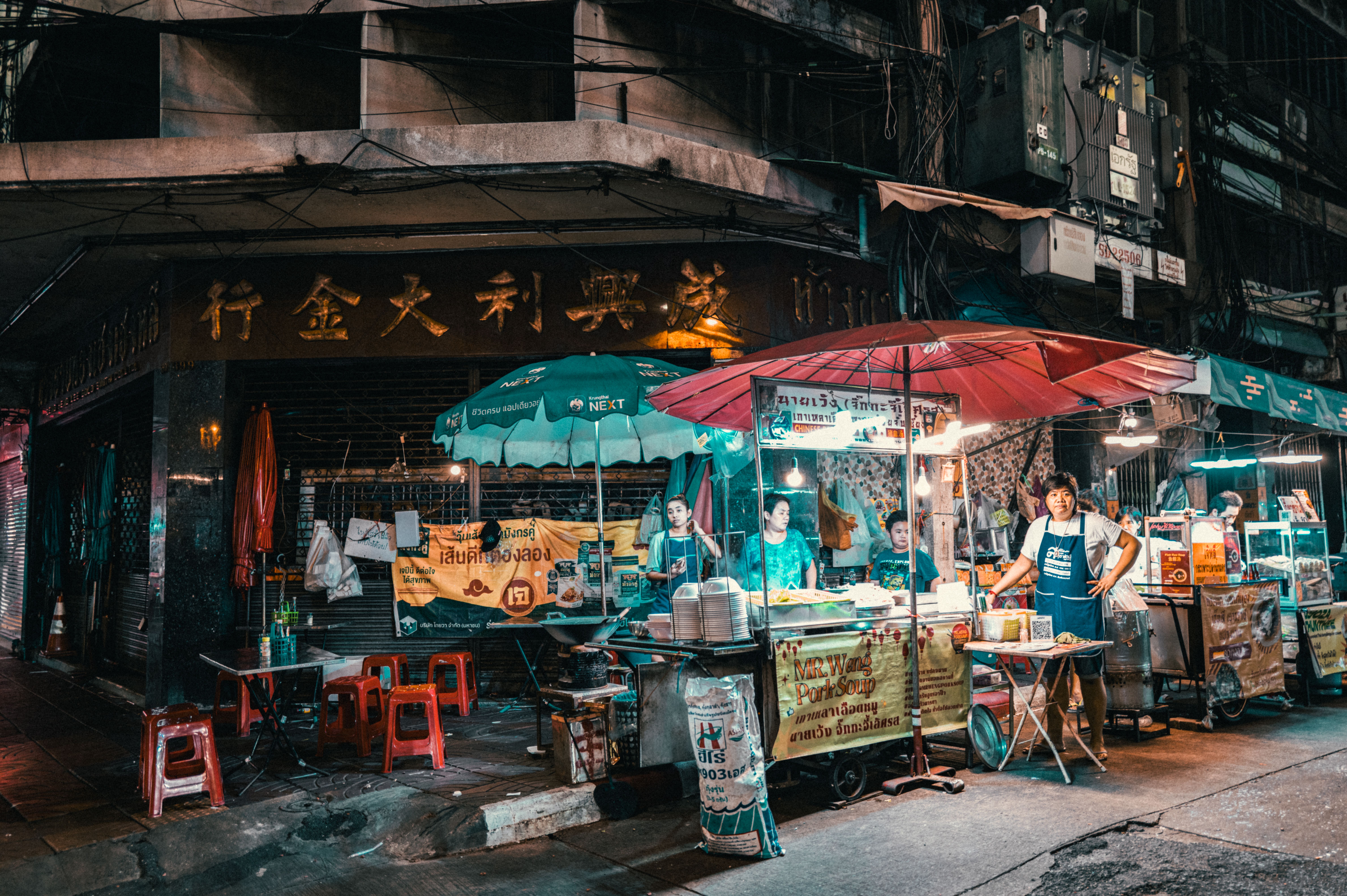 Bustling night market street food vendors serving hungry crowds in Bangkok, a top city for food and late-night eats